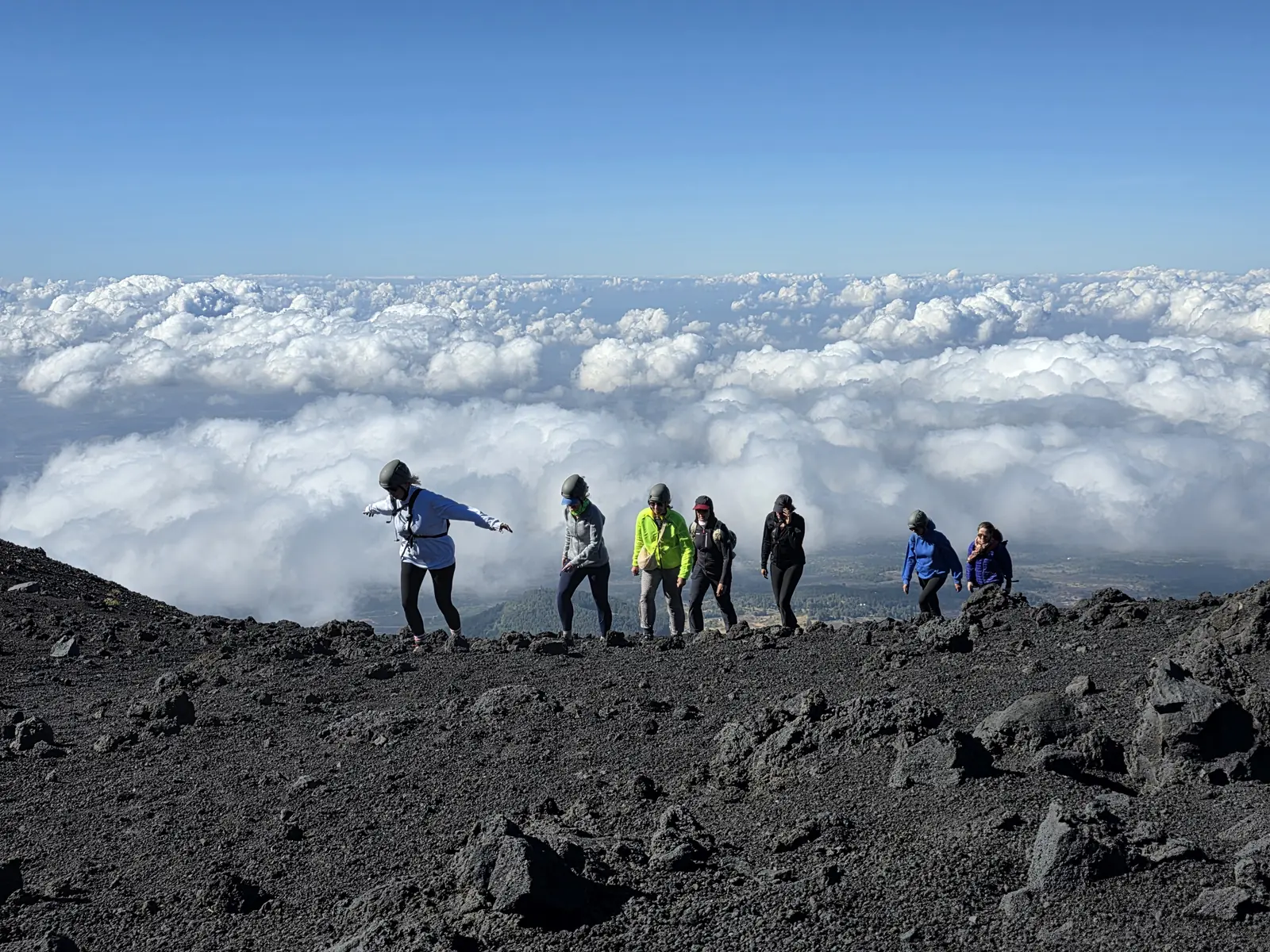 Group hiking above the clouds on Etna's south side, above the cable car